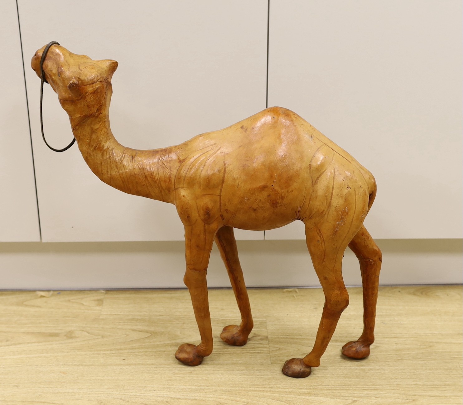 A Liberty style leather bound model of a camel, 64.5cm
